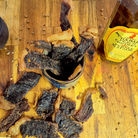 Biltong strips in a shallow small pot with chutney bottle